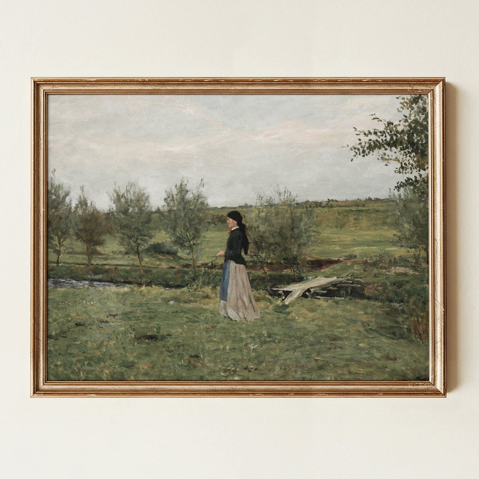 Framed painting of a woman walking in a landscape with trees and a path.