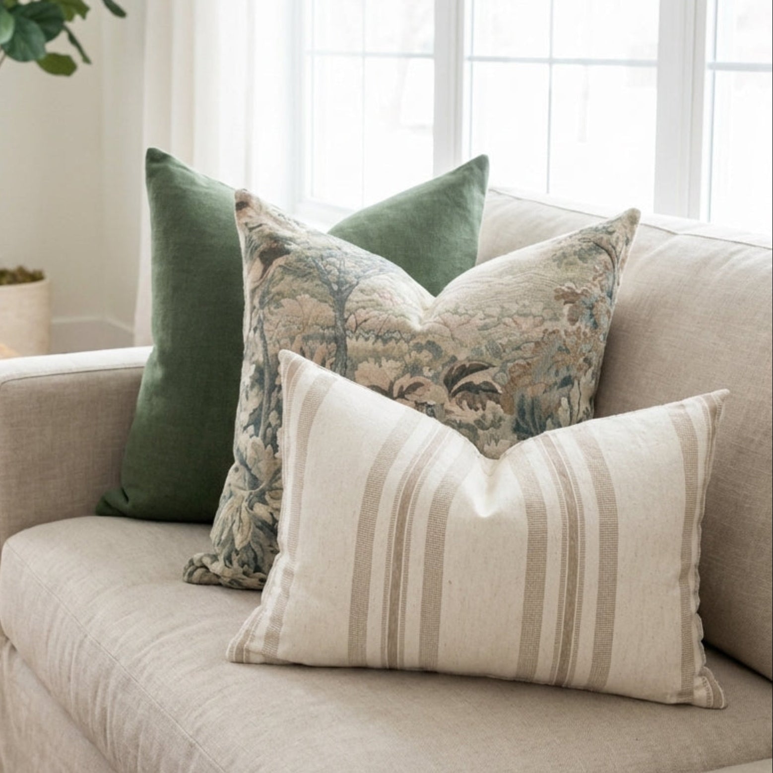Full-body view of Callahan pillows arranged on a neutral linen sofa in a bright, cozy living room, highlighting size, texture, and hidden zippers.