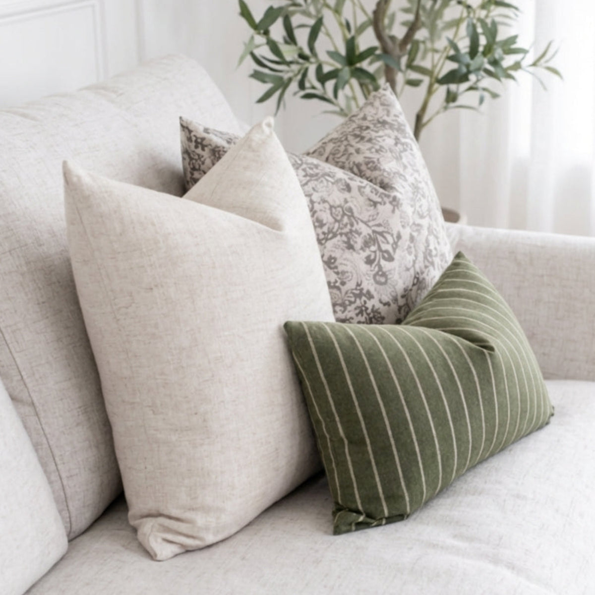 Close-up of textured pillow covers with hidden zippers on a bright, inviting sofa, showcasing fine fabric details in natural light.