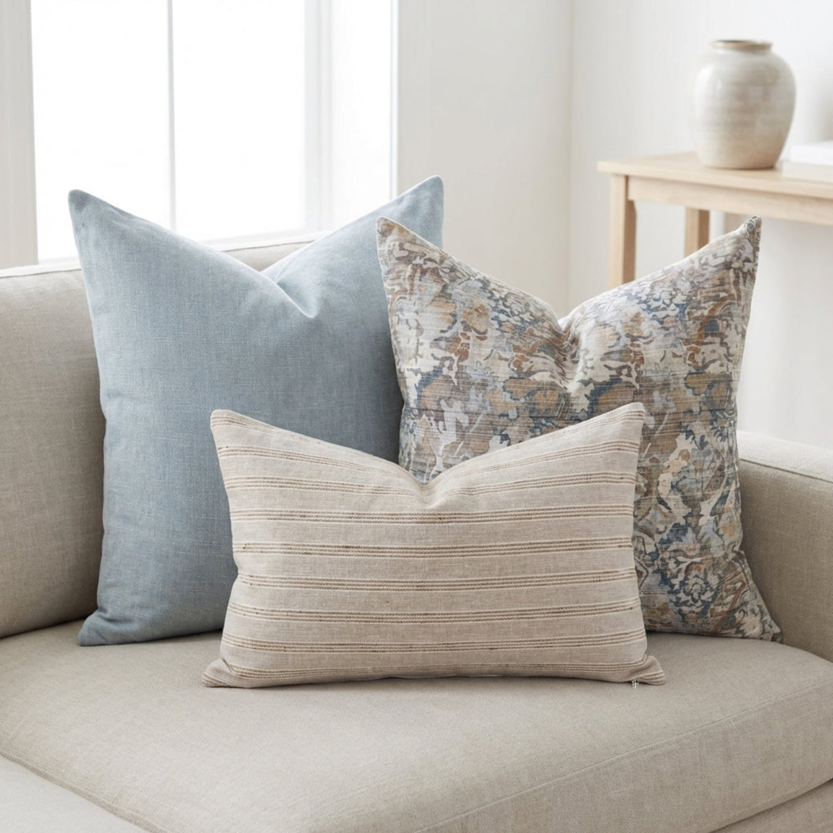 Close-up of the Grady pillow showcasing its pattern and fabric texture on a neutral, airy sofa.