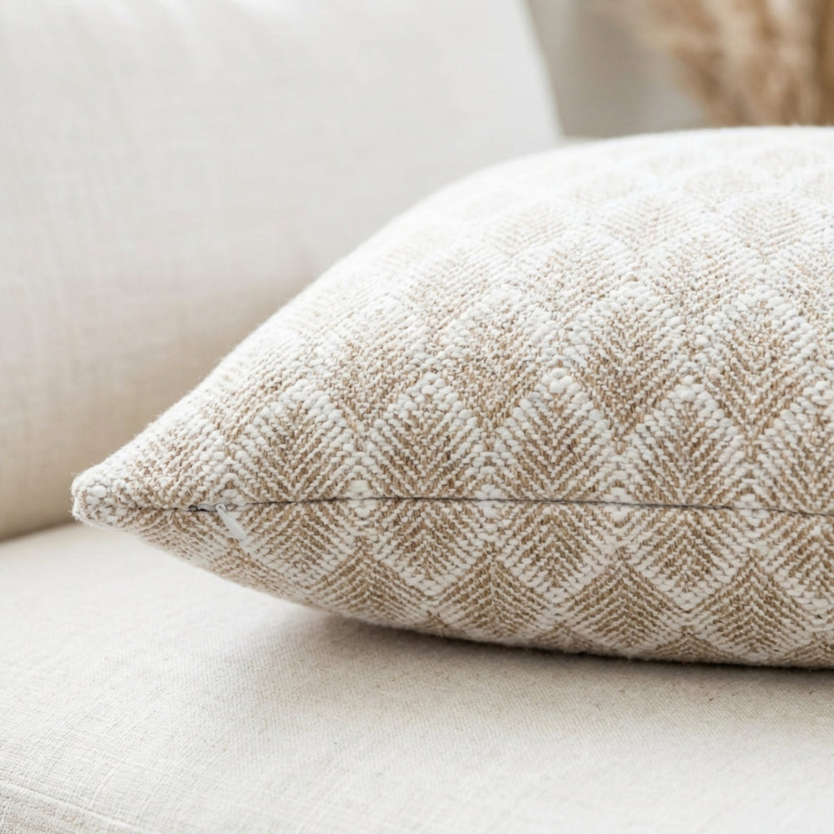 Close-up of the Whitaker Pillow Cover highlighting its woven geometric pattern and fine texture in a bright, airy setting with hidden zipper detail.