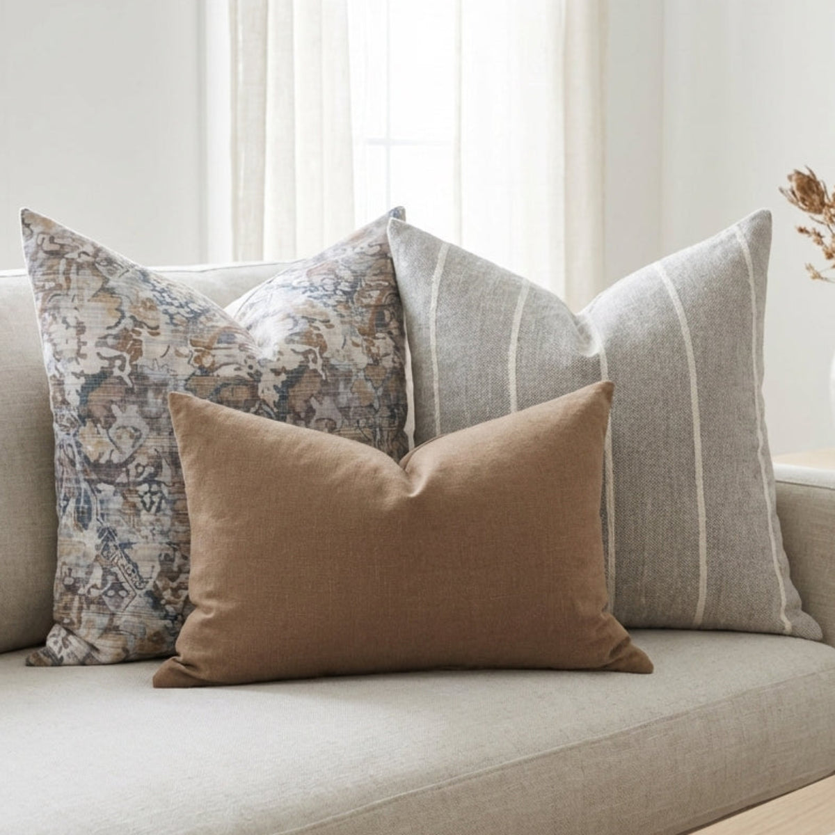 Softly arranged Gage Sofa Combo 5 pillows on a plush sofa in a serene, airy modern living room with neutral tones and diffuse lighting.