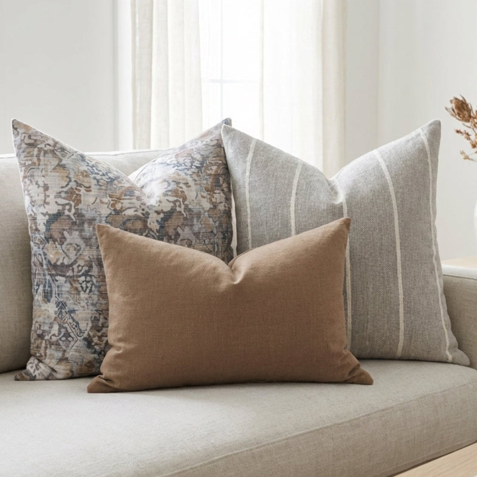 Softly arranged Gage Sofa Combo 5 pillows on a plush sofa in a serene, airy modern living room with neutral tones and diffuse lighting.