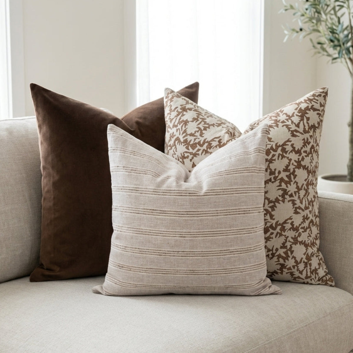 Full scene of Mixed Combo 6 pillows arranged on a light-toned sofa in a modern airy living room, emphasizing relaxed layered style.