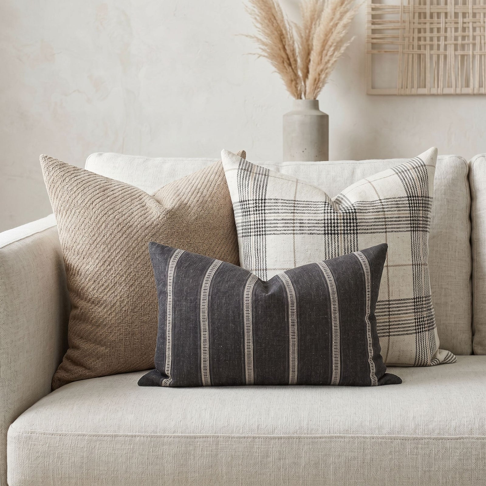 Close-up of Monroe Sofa Combo 1 pillows on a neutral-toned sofa in a bright, airy living room highlighting textures and patterns.