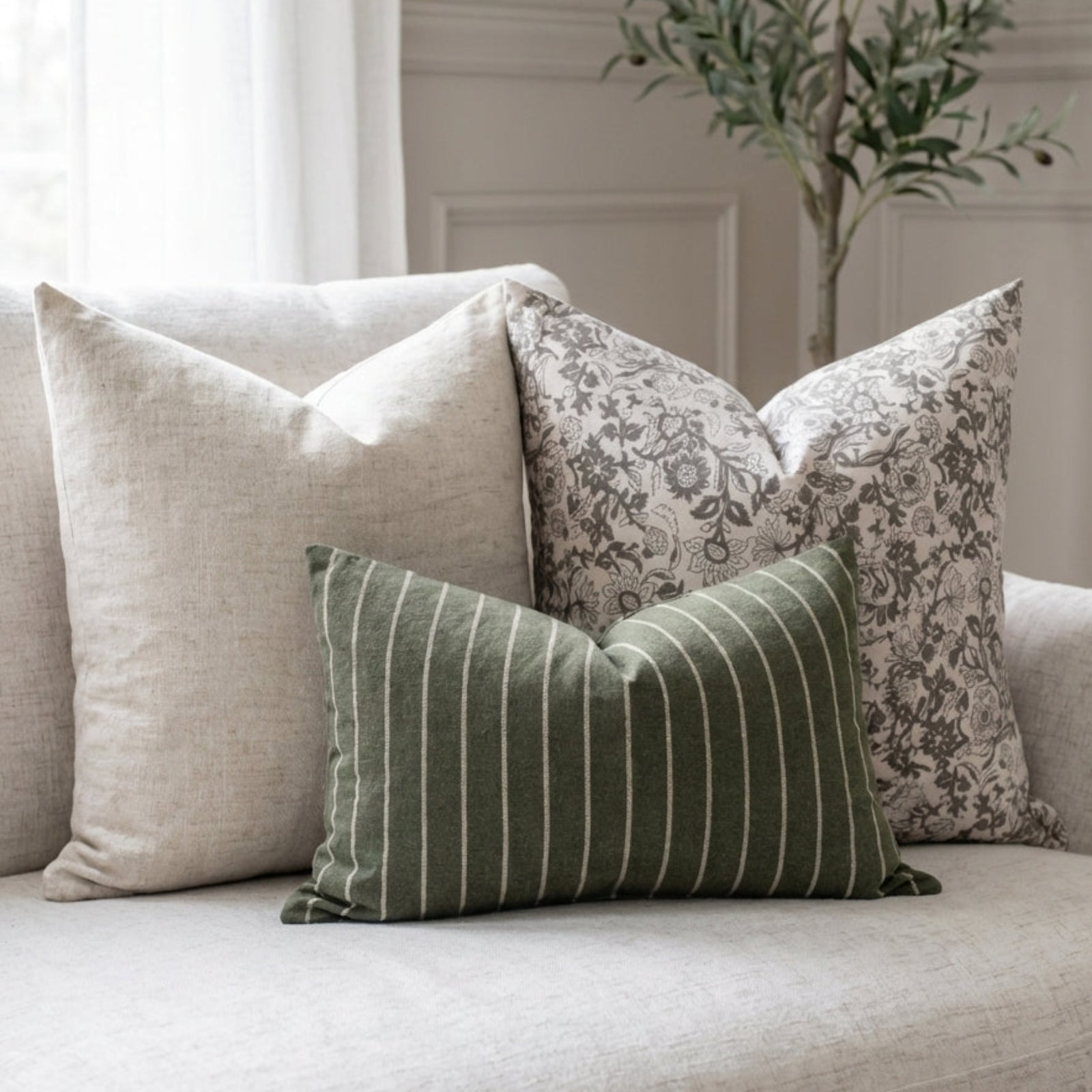 Serene living room scene with set of three neutral pillow covers on a plush sofa, soft natural light, minimalist cozy decor.