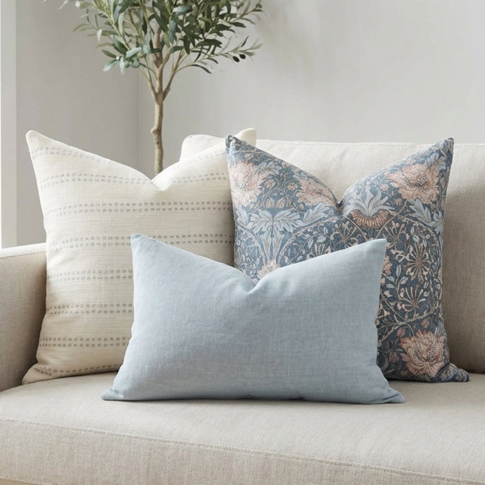 Pillow covers from the Ronan Sofa Combo 2 set arranged on a modern neutral-toned sofa in an airy and bright living room.