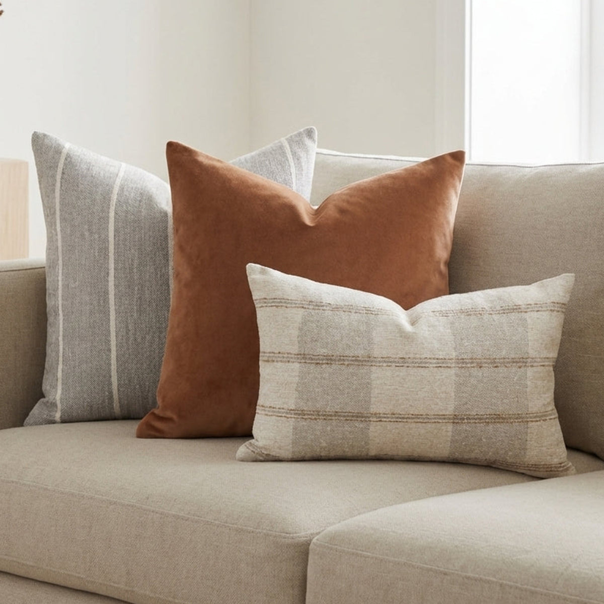Modern living room with sofa styled with Gage pillow covers, emphasizing fabric textures and subtle pattern details in a bright, minimal environment.