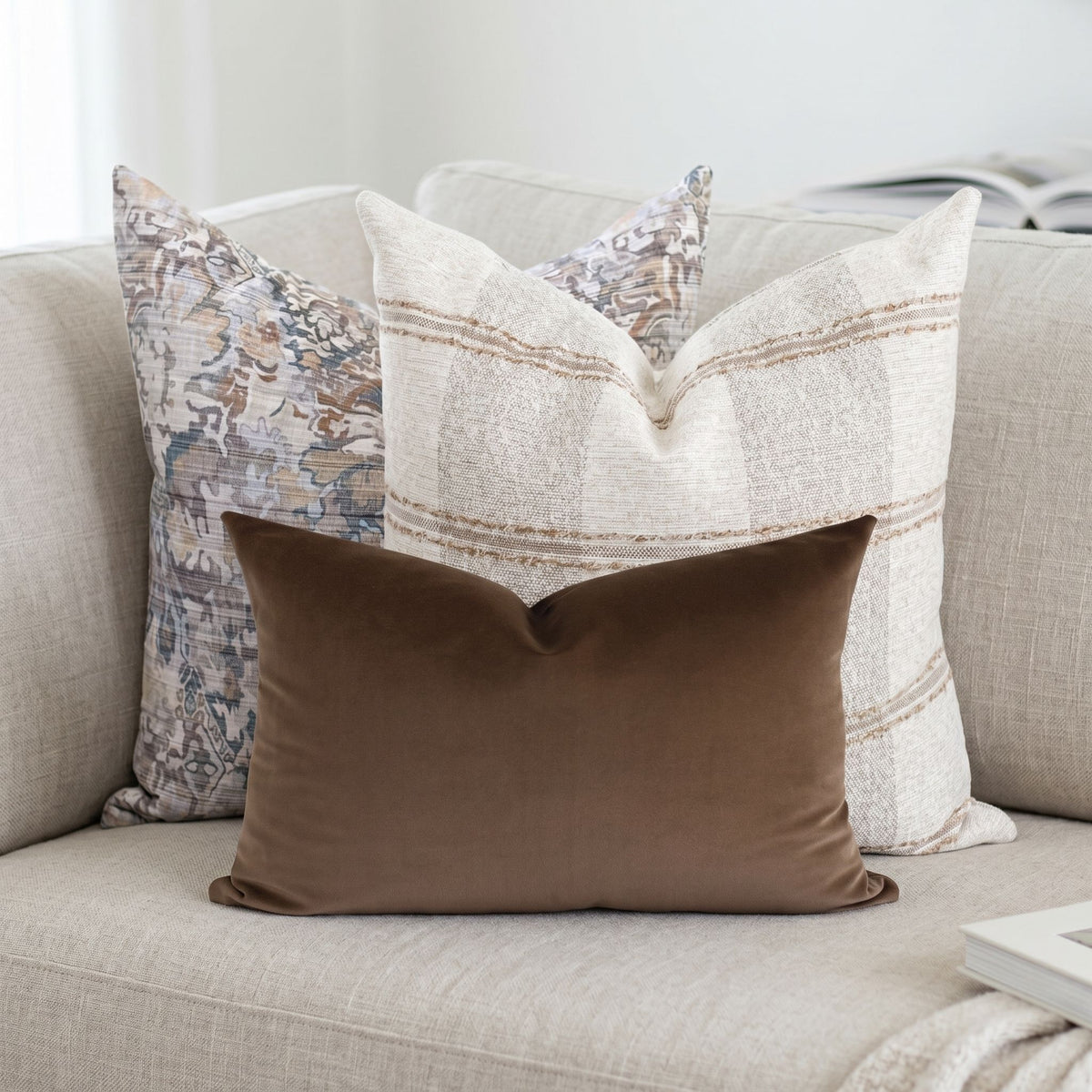 Close-up of Stetson pillow covers on a neutral sofa, highlighting texture and fabric details in a minimalist setting.