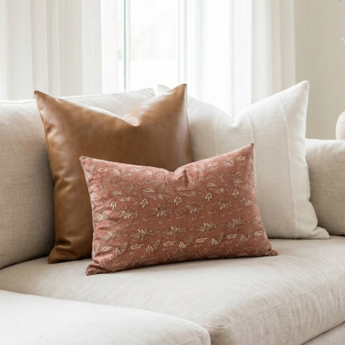 Petite terracotta floral pillow cover on a neutral-toned sofa in a modern, airy living space, showcasing vintage-inspired pattern and intricate terracotta rust tones.