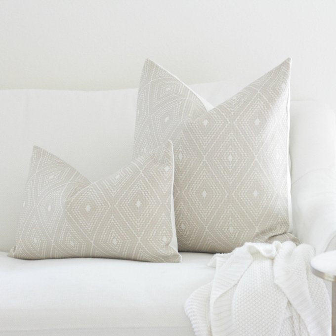 Cream geometric throw pillow cover with neutral diamond pattern on white background