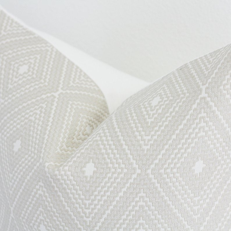 Cream geometric throw pillow cover with neutral diamond pattern on white background